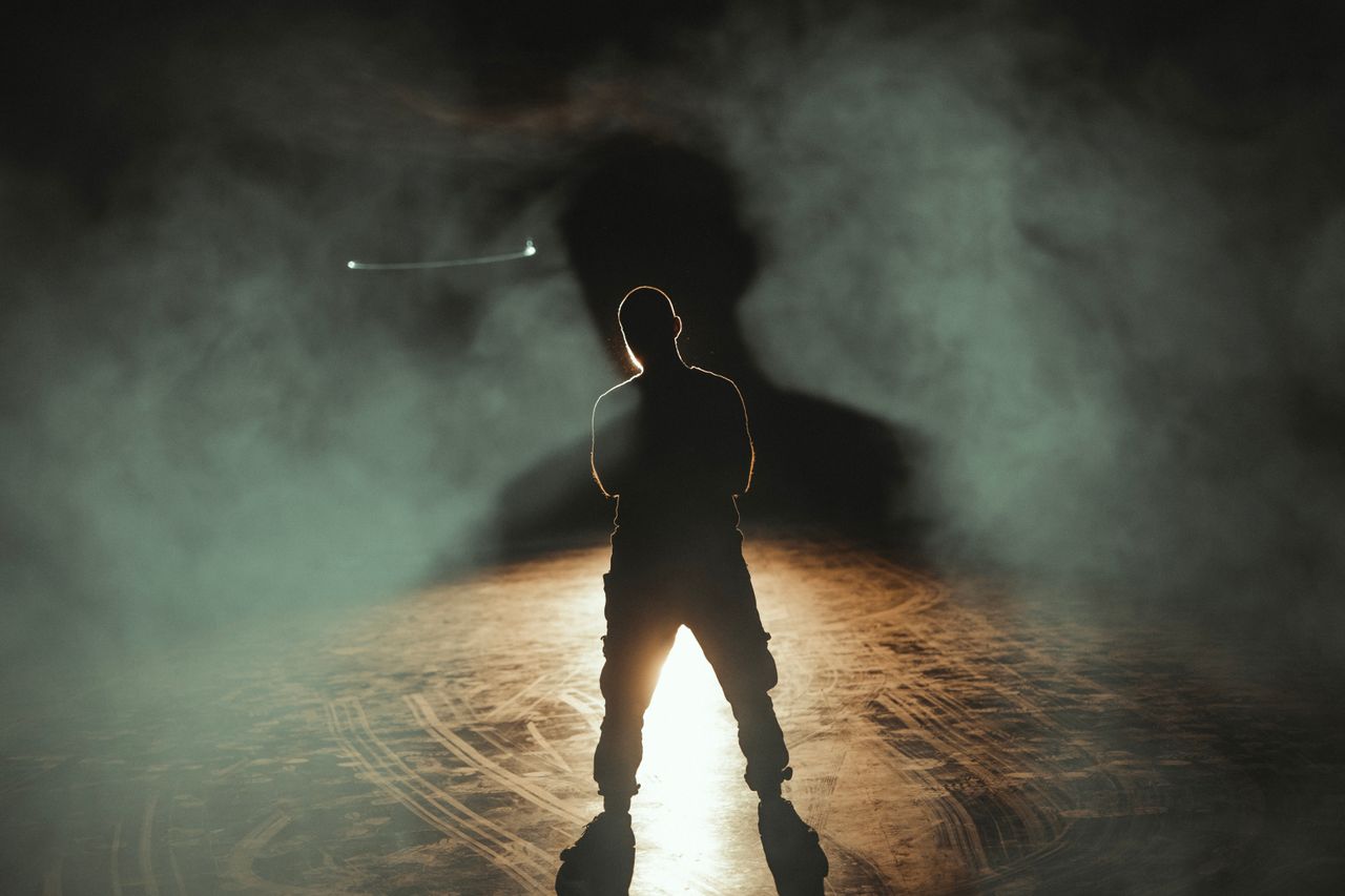 services-01 A dramatic silhouette of a man standing in smoke with backlighting, creating a mysterious atmosphere.