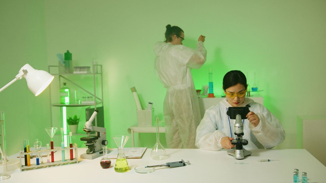 services-03 Scientists wearing protective suits conduct research in a modern laboratory setting.